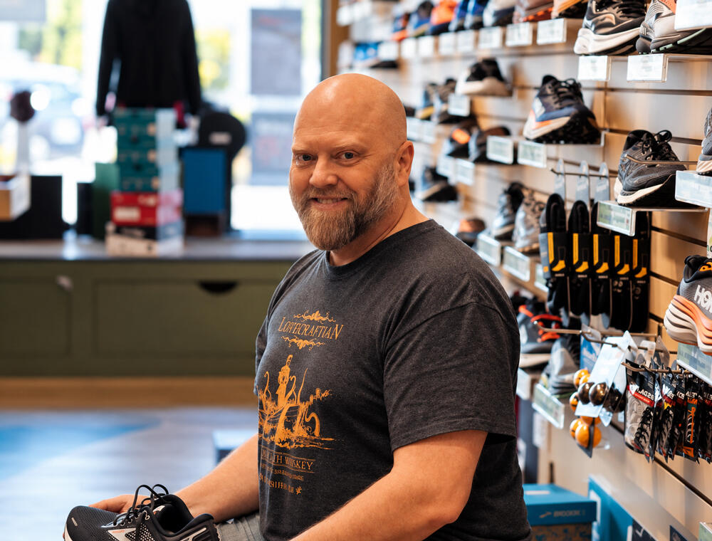 Andy Ronald, owner of Extreme Runners and Momentum Footwear, smiling in his Courtenay shoe store.